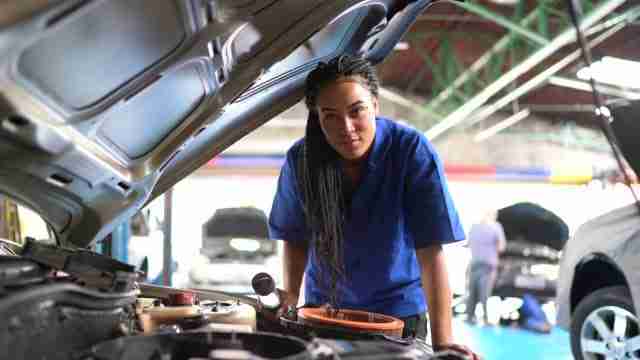 Portrait of woman repairing a car in auto repair shop